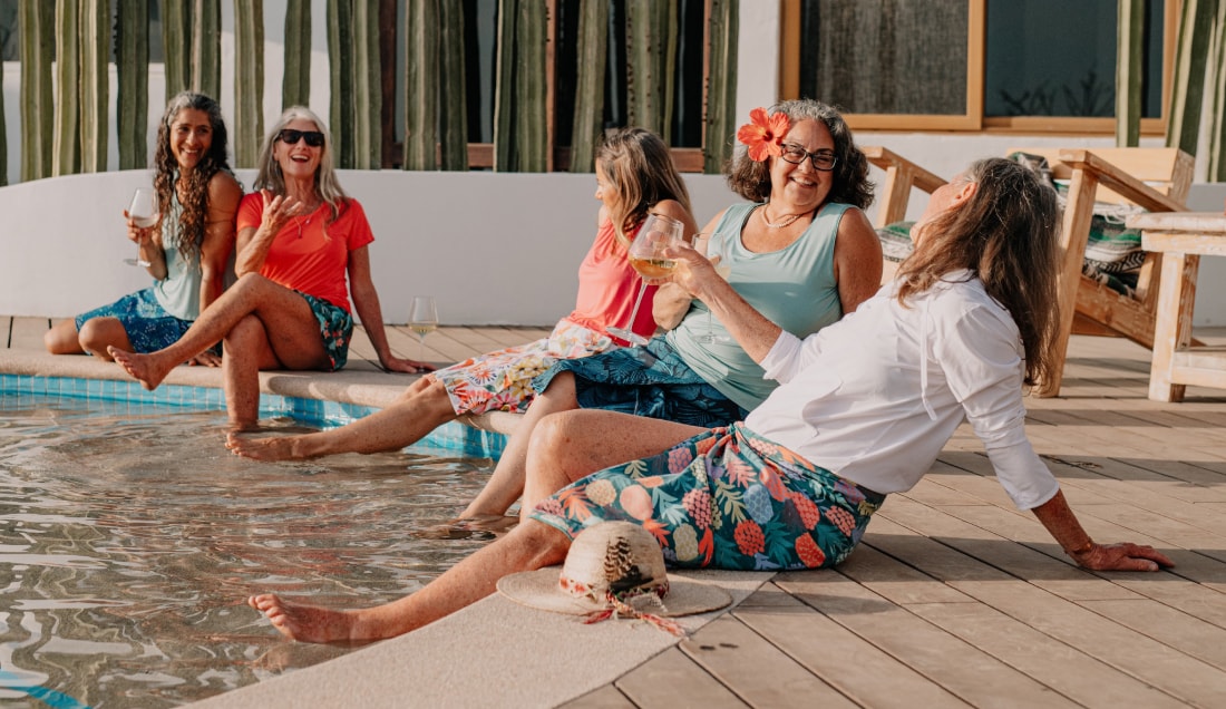 A group of women sitting around the pool in their ripskirts.